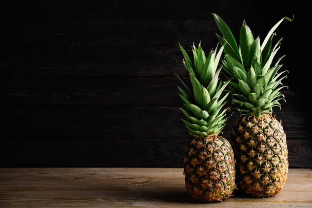 Fresh ripe juicy pineapples on wooden table. Space for text - Фото, изображение
