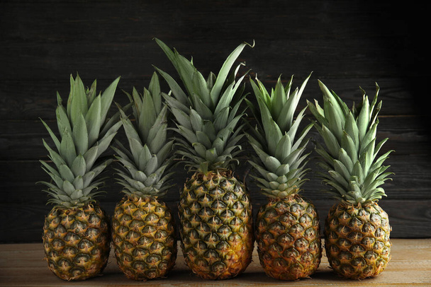 Fresh ripe juicy pineapples on wooden table - Foto, Bild
