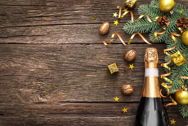 Bottle of champagne with christmas decorations on wooden background. Top view. Copy space. - Foto, immagini