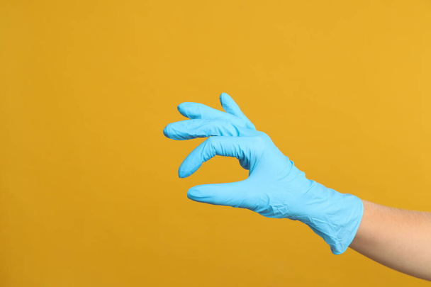 Doctor in medical gloves showing OK gesture on yellow background, closeup. Space for text - Foto, immagini