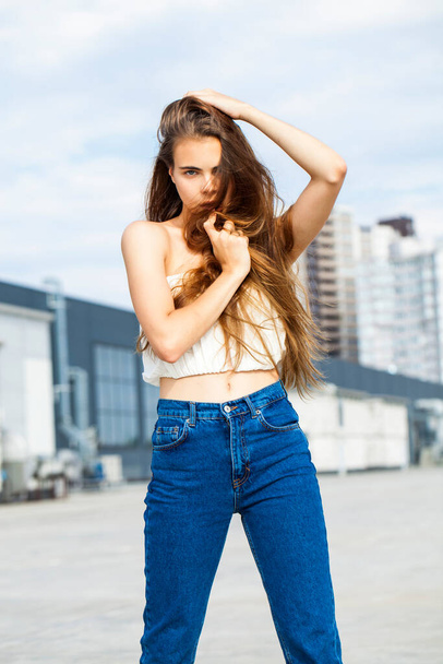  portrait of a young beautiful brunette woman in blue jeans - 写真・画像