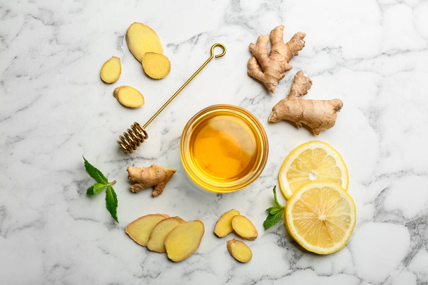Ginger and other natural cold remedies on white marble table, flat lay - Foto, Bild