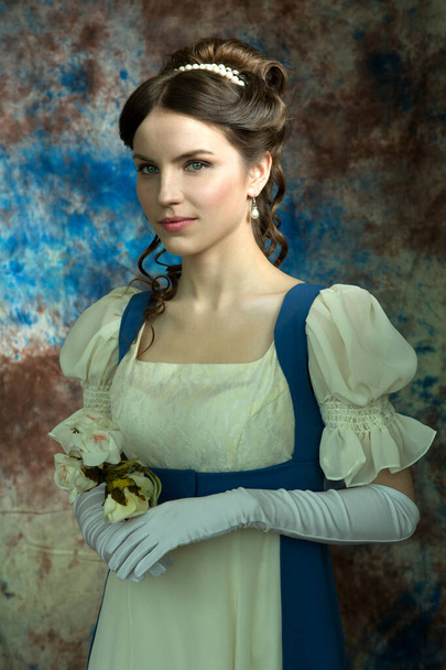 Beautiful young woman in historical costume on blue background - Photo, Image