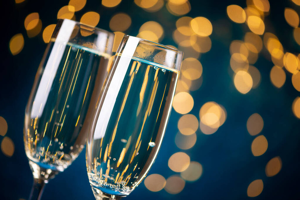 Close-up two glasses of champagne against bokeh lights background. New Year celebration concept - Fotó, kép