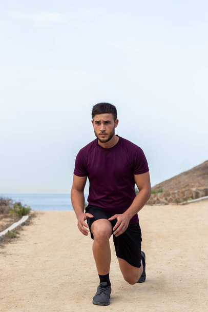 Young athlete man doing lunges outdoor - Foto, Bild