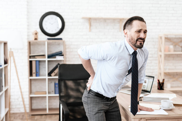 Man in office grabbed his sore back and suffers. - 写真・画像