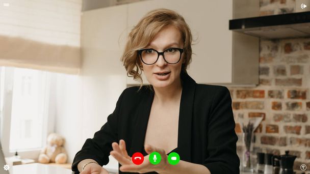 Μια οθόνη επιτραπέζιου υπολογιστή της εφαρμογής τηλεπικοινωνιών κατά τη διάρκεια μιας συνομιλίας βίντεο στην οποία η γυναίκα ειδικός διαφωνεί για τις επιχειρήσεις από το σπίτι. - Φωτογραφία, εικόνα
