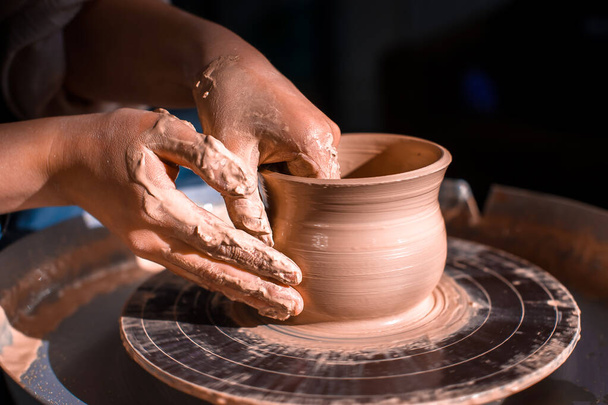 Potter maestro scultore donna lavora con argilla su una ruota Potters e al tavolo con gli strumenti. Primo piano. - Foto, immagini