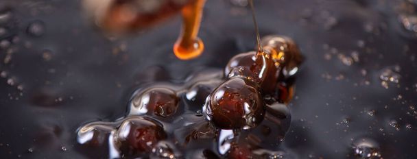 Cooking, boiling brown sugar flavored tapioca pearl balls, ingredient of bubble tea, preparing food and drink, close up, recipe cookbook steps design concept. - 写真・画像