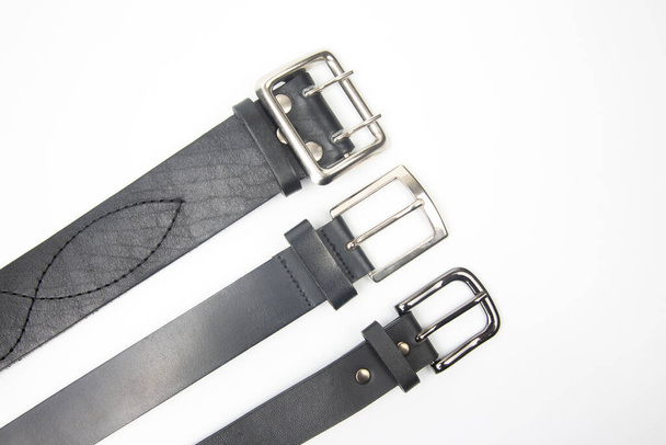 tres cinturón de cuero negro sobre fondo blanco - Foto, Imagen