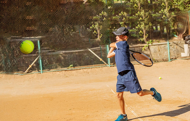 A fiatal teniszező részt vesz az első versenyeken. Sikeresen kezeli a legnehezebb labdákat.. - Fotó, kép