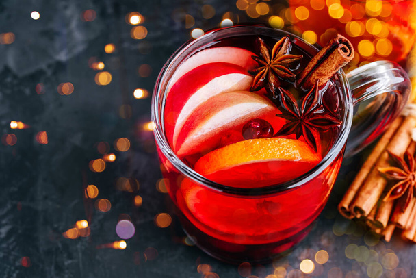 Christmas Mulled Wino z przyprawami i owocami na ciemnym tle, przestrzeń kopiowania. Tradycyjny gorący napój na święta - Zdjęcie, obraz