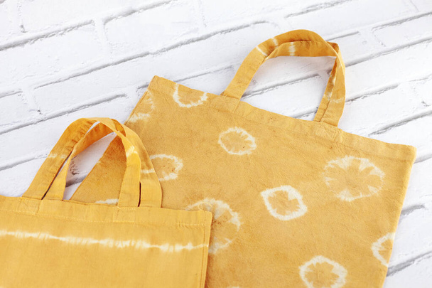 Bolsa de algodón de tela naranja pintada con técnica shibori. Bolso de mano. Colorante natural con achiote - Foto, imagen