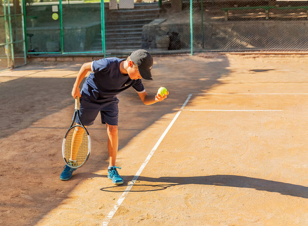 Le jeune joueur de tennis participe à ses premières compétitions. Il gère avec succès le ballon le plus difficile sert. - Photo, image