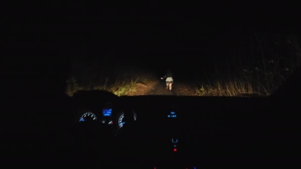 Mujer asustada huyendo de la persecución del coche por la noche - Imágenes, Vídeo