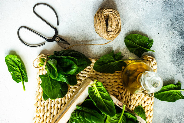Organic food concept with fresh organic baby spinach leaves and oil on light background - Foto, Imagem