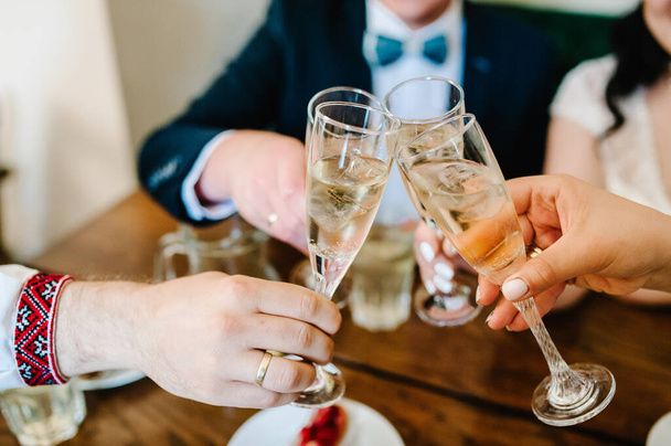 Celebration. Hands holding the glasses of champagne and wine making a toast. The party, alcohol, lifestyle, friendship, holiday, christmas, new year, wedding and clinking concept. - Фото, зображення