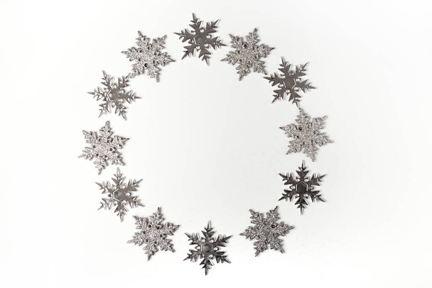 Argent ornement de Noël flocon de neige sur fond blanc vue de dessus. Carte de voeux Noël et Fêtes, cadre - Photo, image