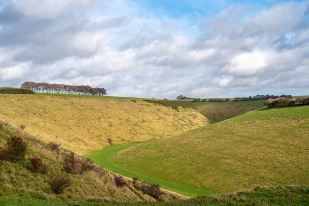 Ein Blick auf Fairy Dale, ein Tal in den Yorkshire Wolds in der Nähe von Burdale an einem sonnigen Tag mit bewölktem Himmel. - Foto, Bild