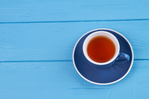 Чашка чая на голубом дереве. - Фото, изображение