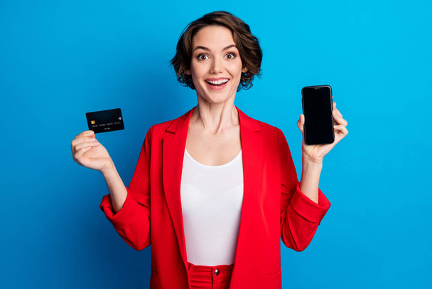 Portrait of attractive amazed cheerful lady demonstrating device card wireless web app pay pass transfer isolated on bright blue color background - Фото, изображение