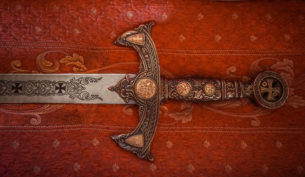Medieval  iron sword on antique red cloth - Valokuva, kuva