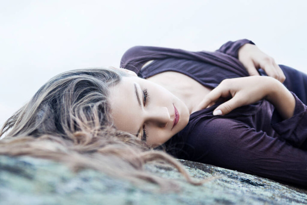 sad young girl lying on a large stone - Фото, зображення