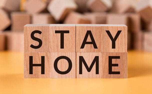 Würfel mit Text Stay Home auf gelbem Hintergrund mit Würfelstapel. Konzeptbild. - Foto, Bild