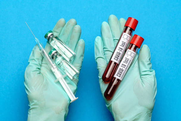 lab technician assistant or doctor wearing rubber or latex gloves holding an ampoule with medicine or vaccine and test tube with blood sample - Zdjęcie, obraz