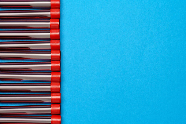 frame made of medicine test tubes with blood samples over blue background - Foto, imagen