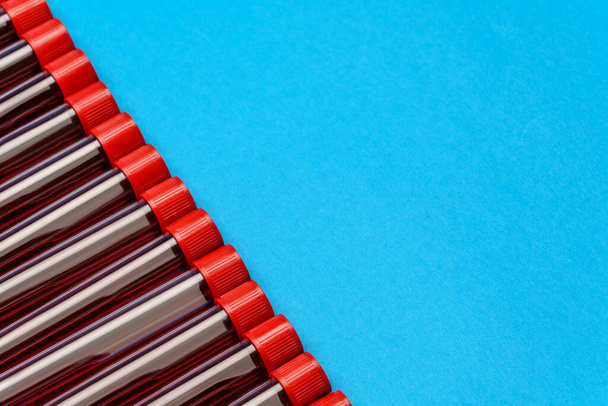 frame made of medicine test tubes with blood samples over blue background - Foto, immagini