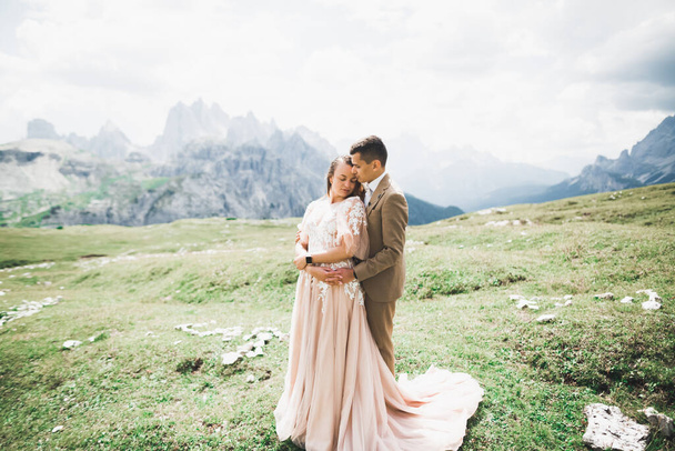 Beautiful gorgeous bride posing to groom and having fun near at mountains with amazing view, space for text, wedding couple - Zdjęcie, obraz