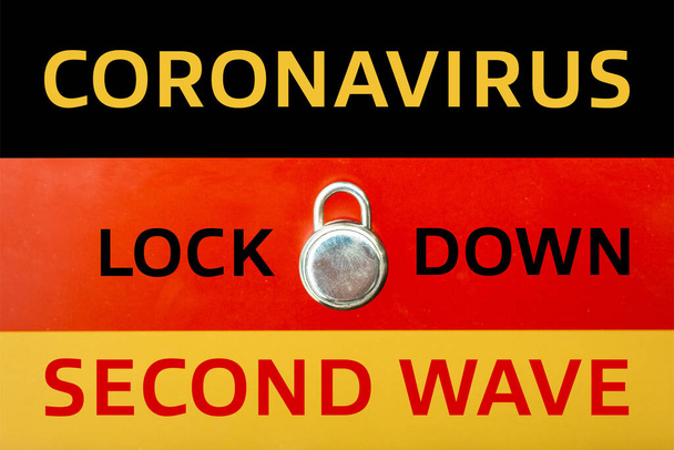 Concept of Second Lockdown in Germany. Skutečný visací zámek umístěný na německé vlajce indikuje druhé národní uzamčení v zemi v důsledku zvýšení počtu případů COVID-19. - Fotografie, Obrázek