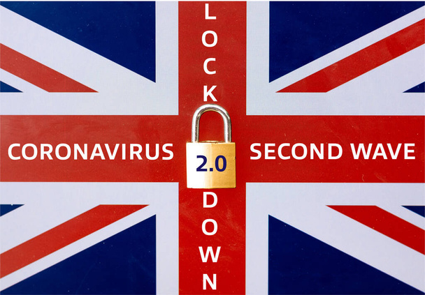 Concept of Second Lockdown in UK. Skutečný visací zámek umístěný na vlajce Union Jack signalizuje druhé národní uzavření ve Velké Británii kvůli zvýšení počtu případů COVID-19. - Fotografie, Obrázek