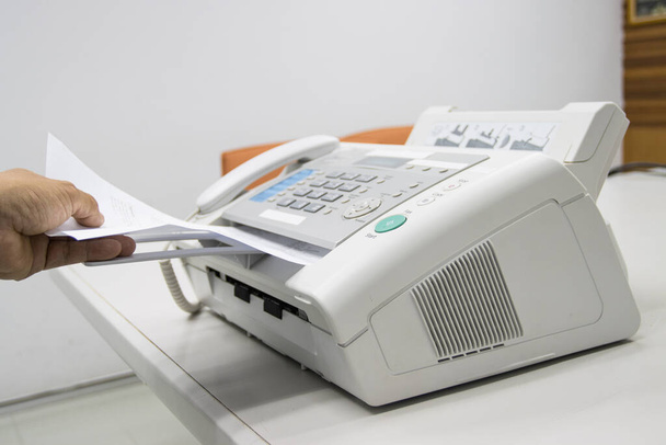 homem mão estão usando uma máquina de fax no escritório, equipamentos para transmissão de dados. - Foto, Imagem