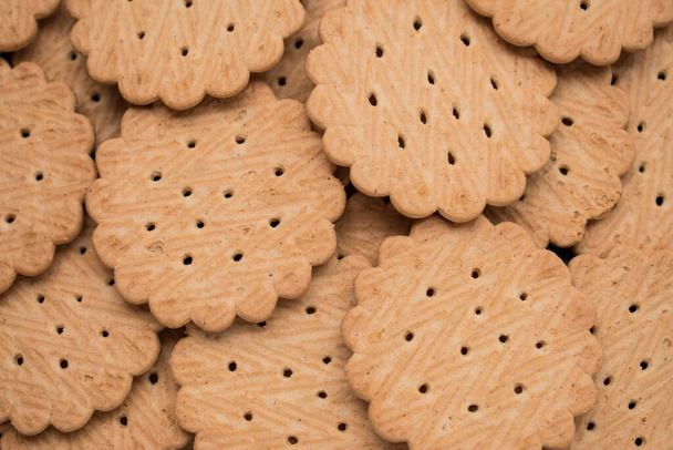 Primer plano de muchas pequeñas galletas sobre una mesa de madera negra   - Foto, imagen