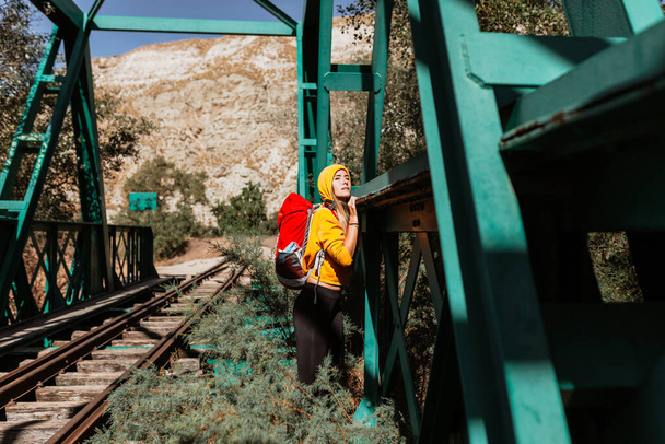 Жінка досліджує стежки і старий залізний залізничний міст
 - Фото, зображення