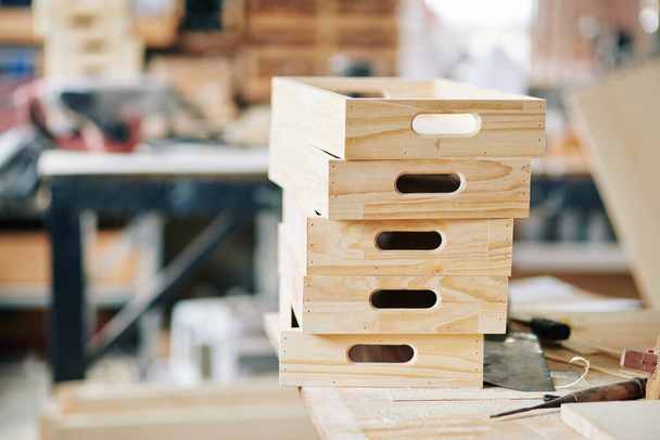 Stack of unfinished wooden crates on table in carpentry shop - Photo, Image