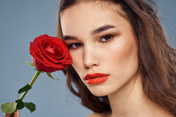 Frau mit einer Rose in den Händen nackte Schultern Abend Make-up rote Lippen - Foto, Bild