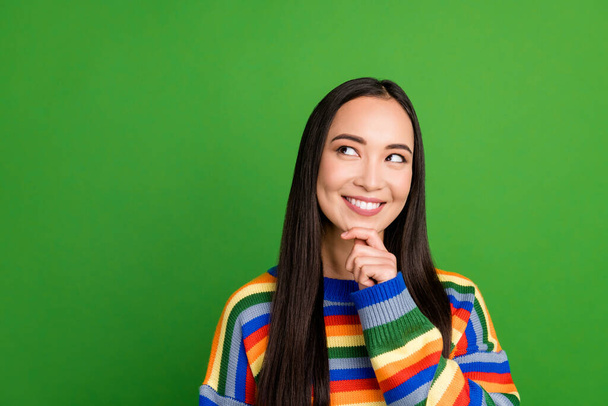 Close-up portrait of lovely pensive cheerful girl wearing striped pullover creating solution copy space isolated over green color background - Foto, Bild