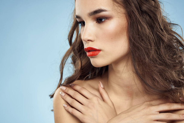 Brunette épaules nues lèvres rouges coiffure à la mode fond bleu - Photo, image