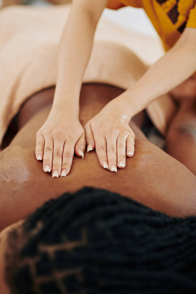 Close-up imagem de jovem afro-americana recebendo spa de volta massagem no salão de beleza - Foto, Imagem