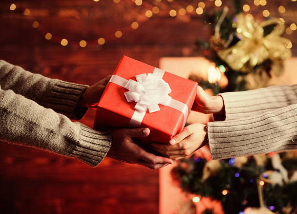 Delivery service. Hands holding gift box. Post service. Share with closest. Gift box in hands close up. Handover concept. Christmas wrapped gift with bow. Spread love around. Giving and receiving - Foto, Imagem