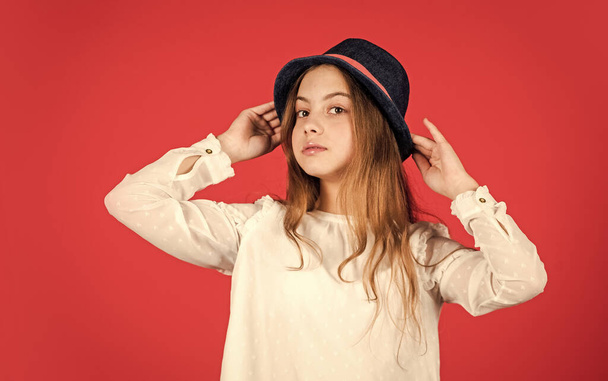 happy small kid retro hat. vintage fashion look. summer accessory collection. child long hair. beauty and style. happy childhood. Young and carefree. retro girl red background - Foto, immagini