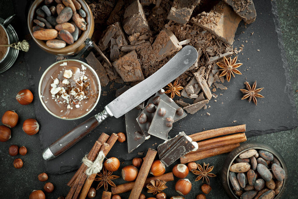 Cioccolato fondente sullo sfondo di fagioli di cacao e oggetti per la cucina - Foto, immagini