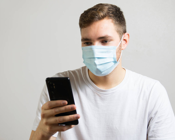 Empresario con mascarilla facial usando un smartphone durante pandemia - Foto, Imagen