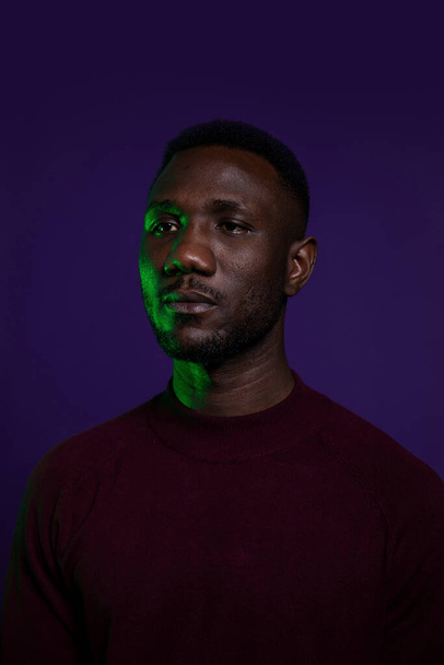 Portrait of young black man with stoic expression looking away. Medium shot. Isolated background.  - Foto, immagini