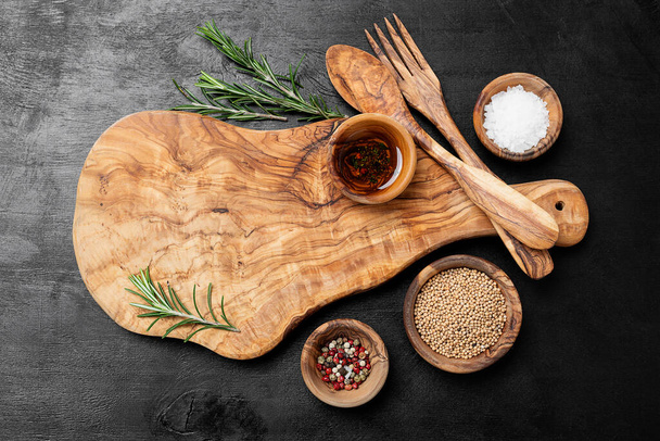 Planche à découper, romarin et épices sur une table en bois noir. - Photo, image
