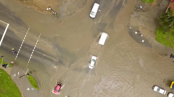 Вид с воздуха на транспортные средства, движущиеся по затопленной дороге с дождевой водой. - Кадры, видео