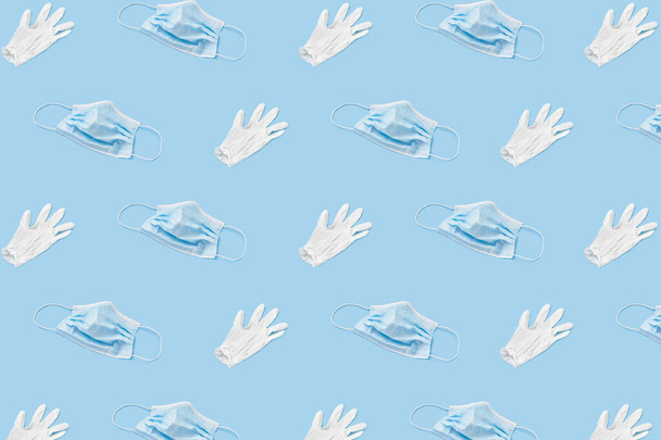 A trendy face mask and rubber glove pattern on a blue background. Pandemic pattern - Photo, Image